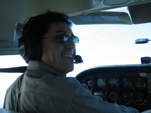 Charles Wainer flying, headset on, instrument panel visible